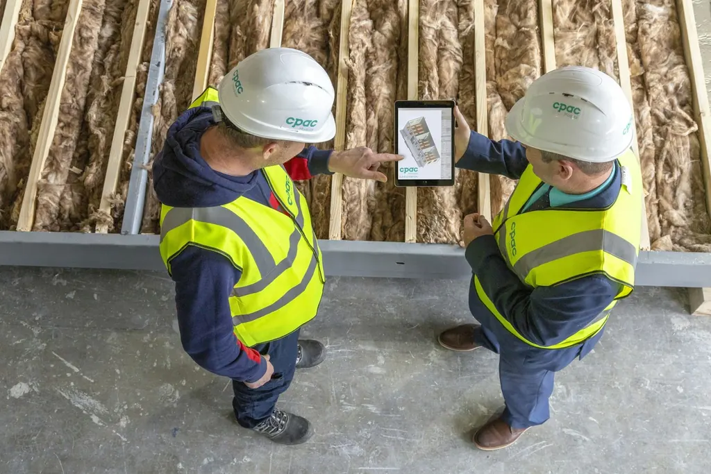 Site workers reviewing plans on a tablet in hi-vis