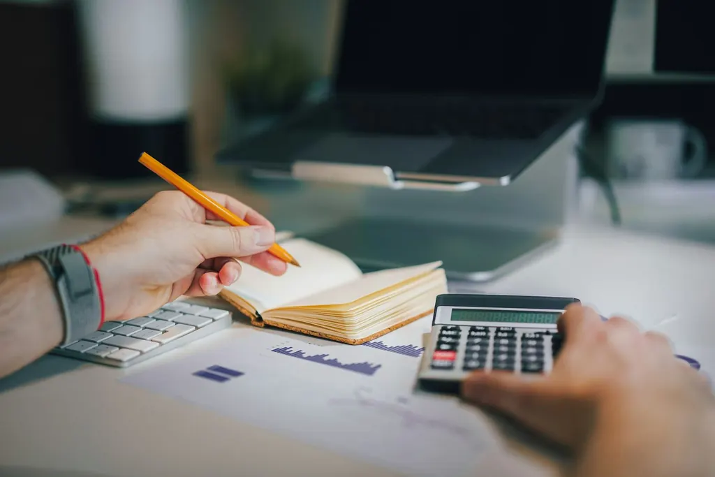 Desk with notebook, calculator and paperwork