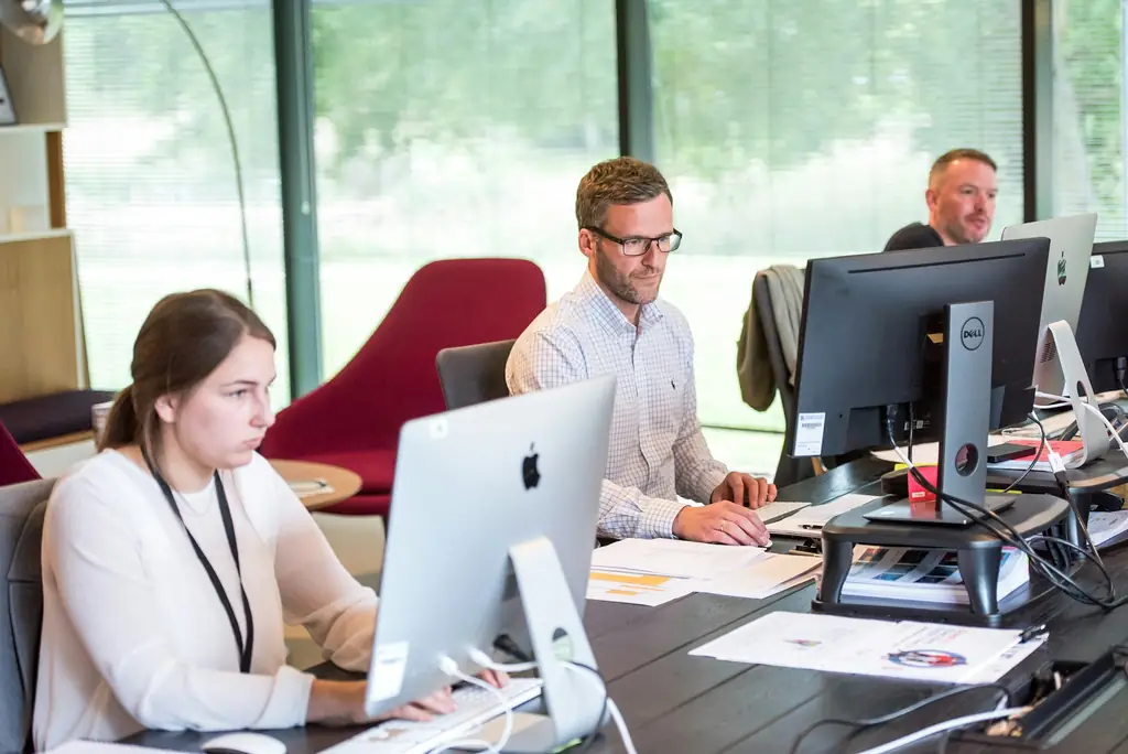 Staff working at iMac and desktop computers in a bright open-plan office