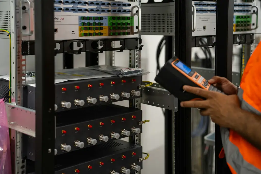 Engineer checking server racks with a handheld diagnostic tool