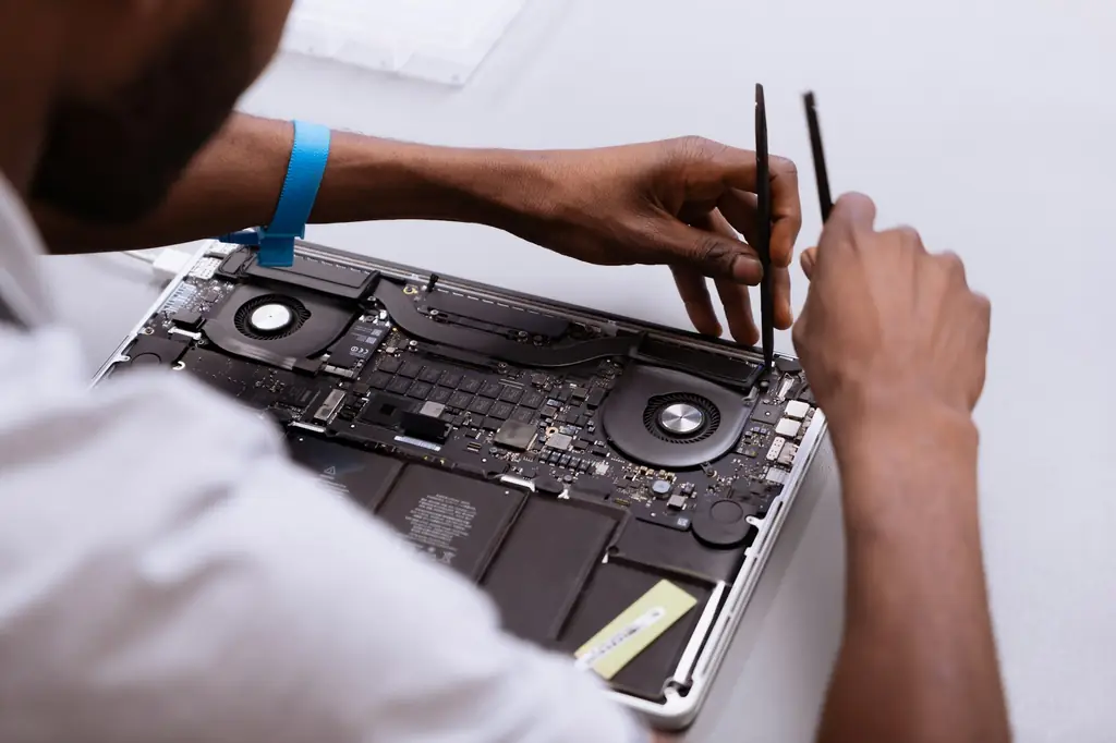 Technician inspecting the internal components of an open laptop