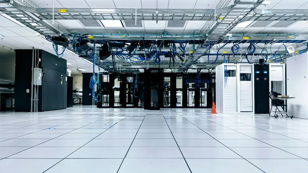 Spacious data centre hall with server cabinets and overhead blue network cabling