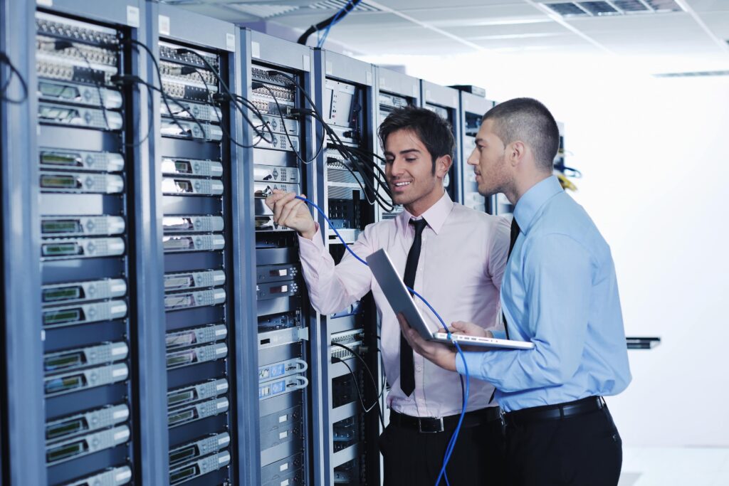 Men in server room performing network management.